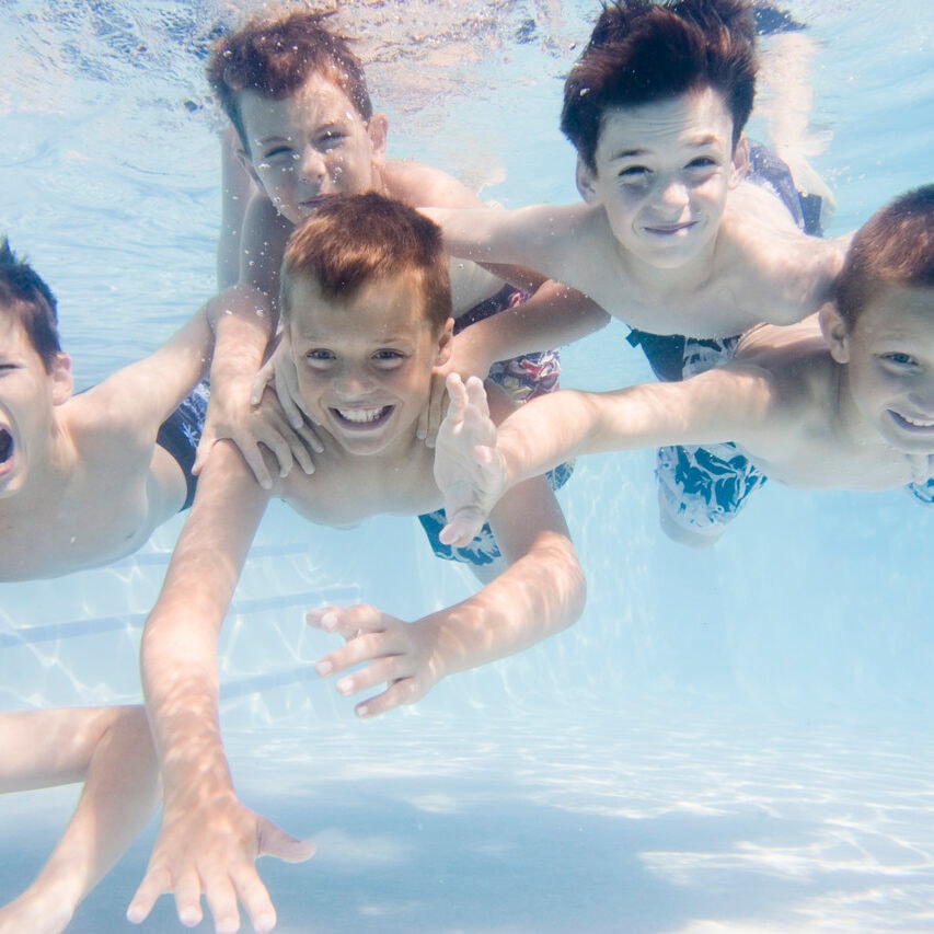 Children swimming underwater at the pool on a Discovery Kids Club field trip